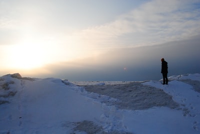 人站在雪山在夕阳下

